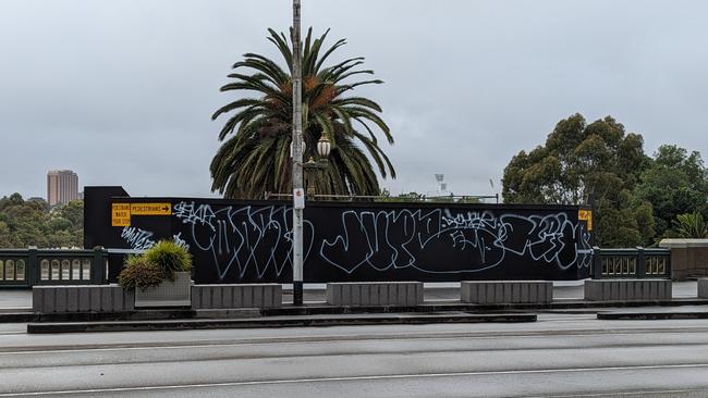 Huge tags on a hoarding on Princess Bridge — one of the city’s busiest thoroughfares — have been left for weeks by the City of Melbourne.