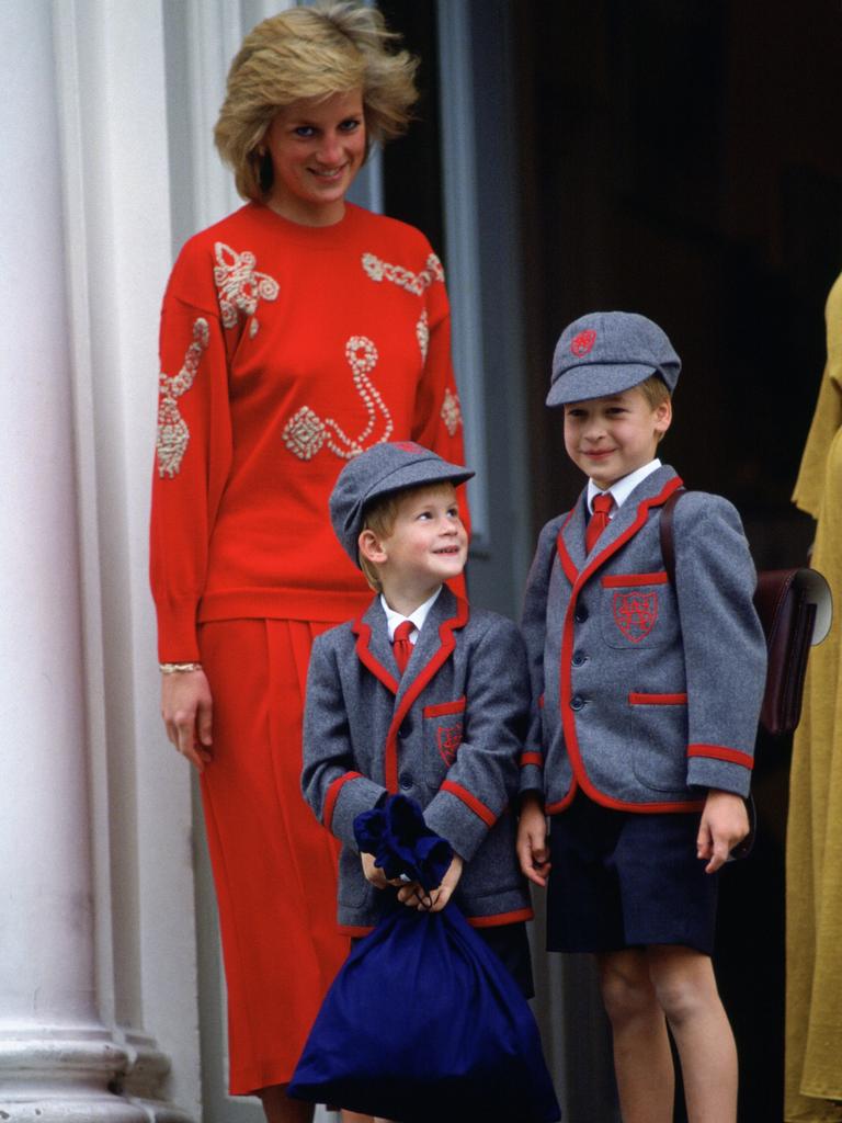 <b>1989:</b> Prince Harry is dropped off by Princess Diana for his first day at school. The adorable royal beams as he stands proudly on the steps of the Wetherby School in Kensington with older brother Prince William. Picture: Tim Graham Photo Library via Getty