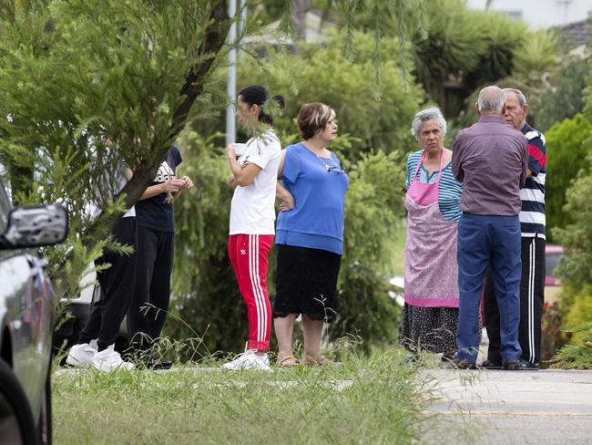 Neighbours gather in the Mill Park street after a man was allegedly stabbed. Picture: Sarah Matray