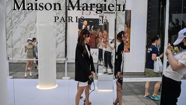 A woman posing for a picture next to a shopping mall in Shanghai earlier this month. Picture: AFP