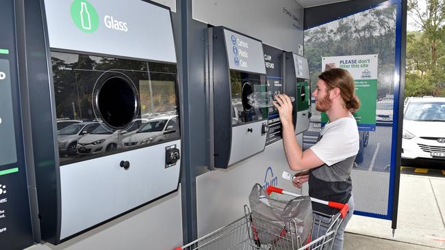 Sam Kelly uses the Return and Earn reverse vending machine at Erina Fair. (AAP IMAGE / Troy Snook)