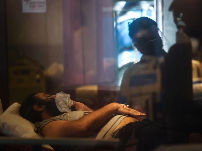 A COVID-19 patient rests inside a banquet hall temporarily converted into a coronavirus ward. Picture: AFP