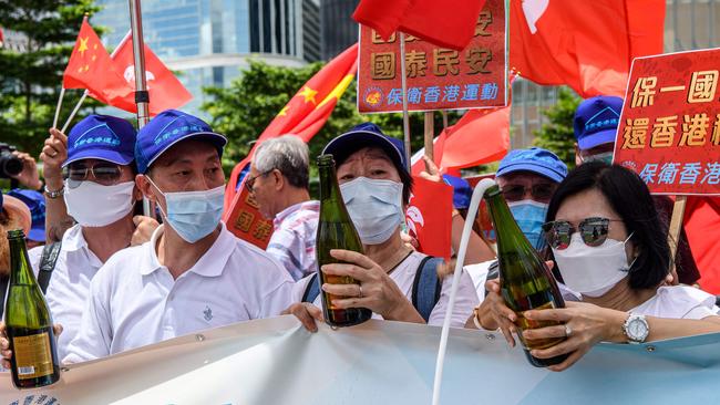 Pro-China supporters pop champagne corks near government headquarters in Hong Kong on Tuesday. Picture: AFP