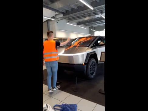 Climate activists drench Cybertruck in orange paint in Tesla showroom