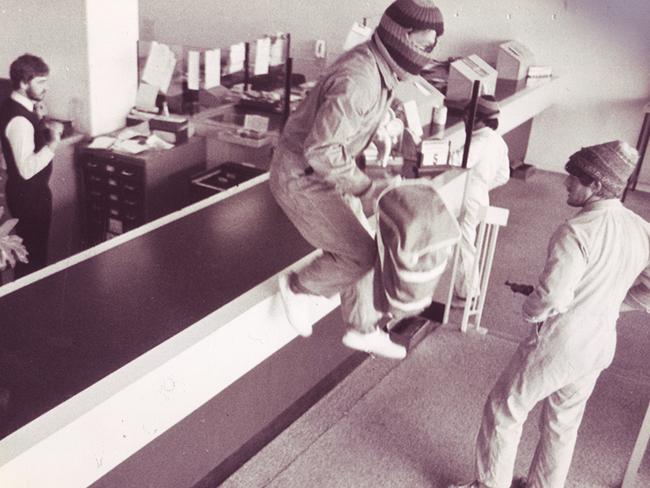 A group dubbed the ‘midget bandits’ rob a bank in Clayton in 1983 in uniform jumpsuits and patterned masks and beanies.