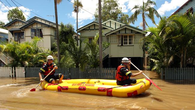 Members of the Queensland Fire and Rescue Service, in a boat, check on the condition and safety of affected houses in Milton.