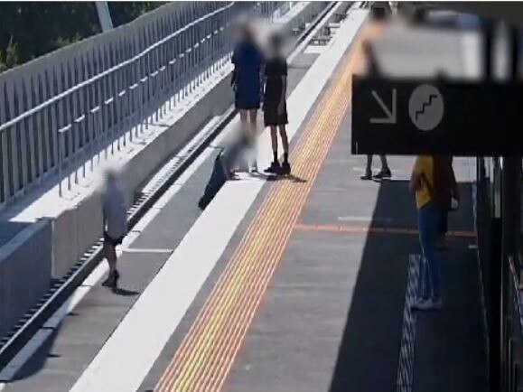 Kids behaving badly at train stationsWestall station - student sit and stand on platform edge using mobile pone