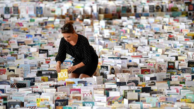 Mandy Alison adds to the thousands of birthday cards sent to Captain Tom Moore for his 100th birthday in the Hall of Bedford School.