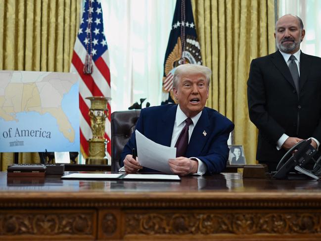 US President Donald Trump speaks in the Oval Office of the White House as he announces reciprocal tariffs, in Washington, DC, on February 13, 2025 as Commerce Secretary Howard Lutnick (R) looks on. Trump announced that he would impose "reciprocal tariffs" on trading partners, opening new fronts in his trade war. The move would match US tariff rates on imports to the levels that other countries impose on US goods. (Photo by ANDREW CABALLERO-REYNOLDS / AFP)