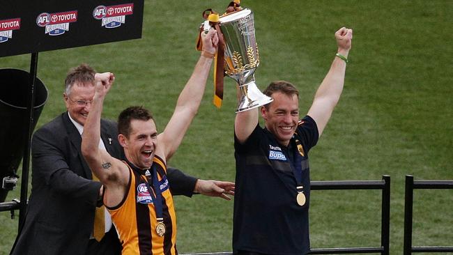 Hawthorn’s Luke Hodge and coach Alastair Clarkson lift the 2015 premiership cup – their third flag in three years. Hodge replaced Sam Mitchell as club captain in 2010.