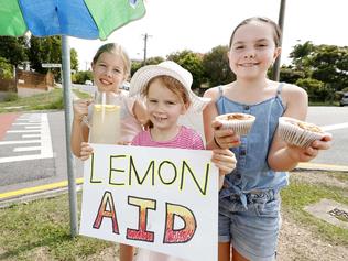Zoe Teahan, 9, Georgie, 6, and Annika Taylor, 9, posing at Bulimba, Brisbane 5th of January 2019.  They're selling lemonade, cookies and muffins to raise money for the Bushfire Appeal.  (AAP Image/Josh Woning)
