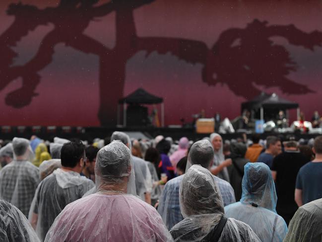 U2 fans wait in the rain for the show to begin. Picture: AAP