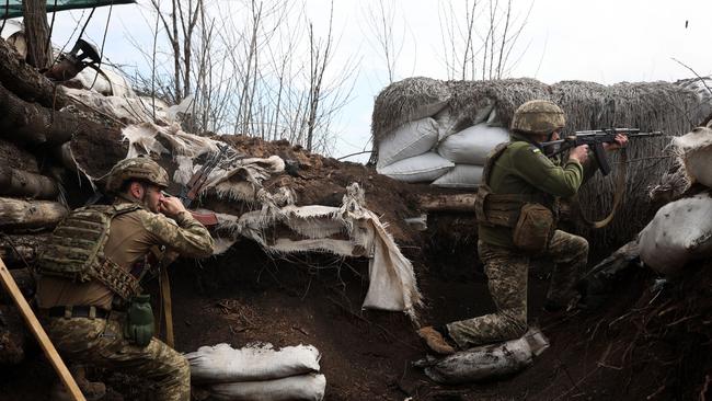 Ukrainian soldiers shoot with assault rifles in a trench on the front line with Russian troops in Lugansk region. Picture: AFP