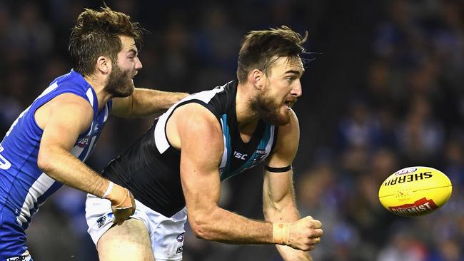 Port Adelaide’s Charlie Dixon handballs as North Melbourne’s Luke McDonald trie to tackle him in round 6 at Etihad Stadium. Picture: Quinn Rooney/Getty