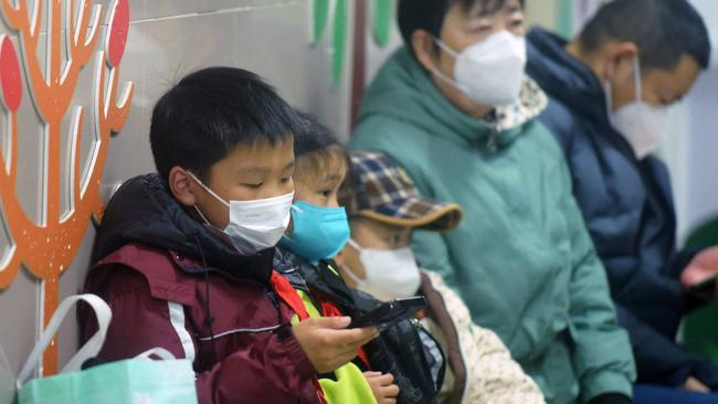 Masked children wait to be seen by medical staff at a hospital in Hangzhou, eastern China's Zhejiang province, amid a surge in cases of the flu-like human metapneumovirus (HMPV). Picture: AFP) / China OUT