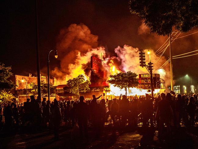 Protesters gather around a liquor store in flames in Minneapolis. Picture: AFP