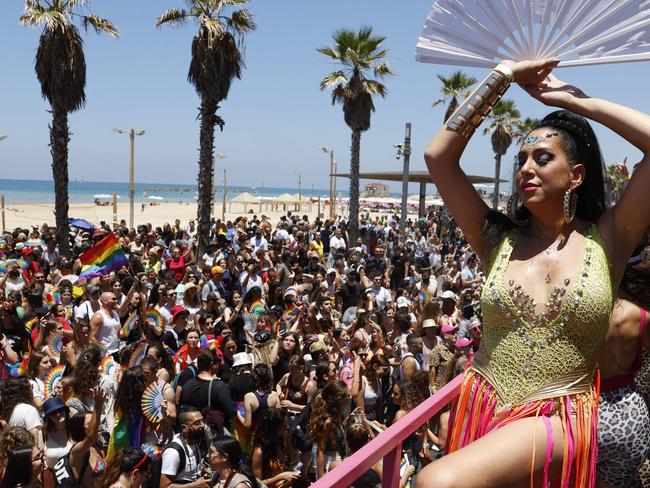 TOPSHOT - Participants attend the first Tel Aviv pride event since before the Covid-19 pandemic on June 25, 2021 even as officials urged marchers to wear masks amid a surge in infections. - Organisers called it the "largest parade of its kind held worldwide since the outbreak of Covid-19. "The last Tel Aviv Pride in 2019 drew a quarter of a million revellers, who danced on colourful floats under rainbow banners in the beachside city. This year's celebration will be more subdued as Israel remains largely closed to tourists due to the coronavirus. (Photo by JACK GUEZ / AFP)