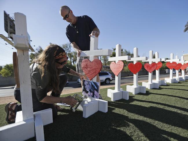 Sherri Camperchioli and Jordan Cassel help set up some crosses to honour the victims of the mass shooting. Picture: AP