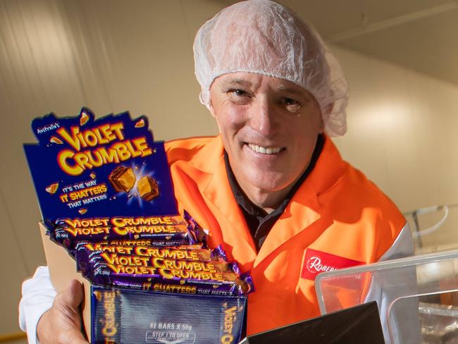 Phil Sims Ceo Robern Menz, with Violet Crumble bars in the Glynde SA factory, for export to the US. Next Monday 26 November, the first shipment of Violet Crumbles will leave the factory in Glynde for the US Ð 77,000 bars (5 tonne equivalent) will be packed onto 14 pallets and then into a 20-foot shipping container.