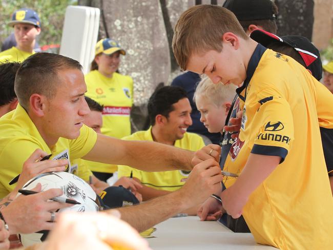 Newly named captain Alan Baro signs a young fan’s shirt at the Central Coast Mariners annual Family Day (AAP image /Mark Scott)