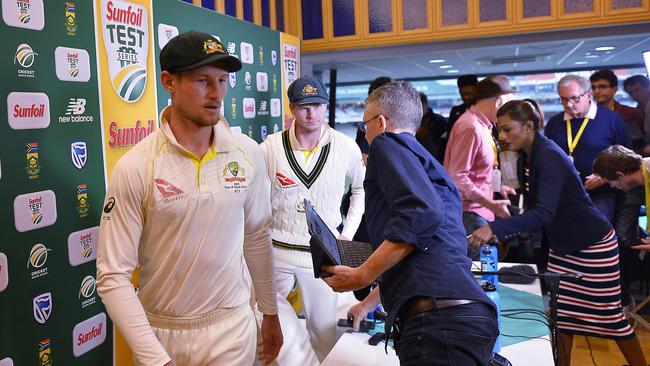 Steven Smith (C) and Cameron Bancroft (L) leave their extraordinary press conference.