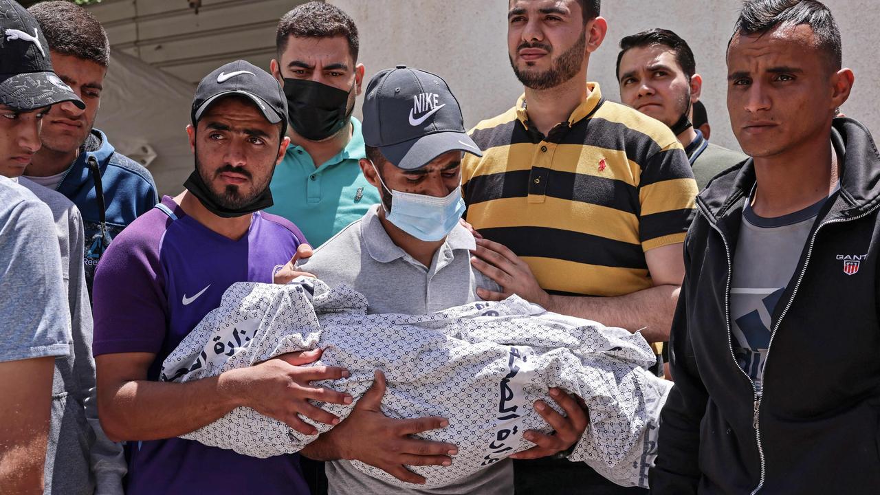 The father of Hur Alzamly, a child killed in an Israeli air strike, carries her shrouded body away from a hospital morgue, before her burial in Rafah in the southern Gaza Strip. Picture: Said KHATIB / AFP