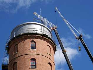 REPAIR JOB: Workers remove the tower roof yesterday. Picture: Mike Knott BUN041018TOWER2