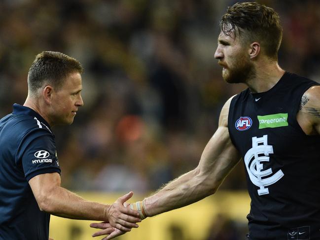 Carlton Blues coach Brendon Bolton (left) slaps hands with Zach Tuohy at three quarter time as the Blues play the Richmond Tigers in round one of the AFL at the MCG in Melbourne, Thursday, March 24, 2016. (AAP Image/Julian Smith) NO ARCHIVING, EDITORIAL USE ONLY