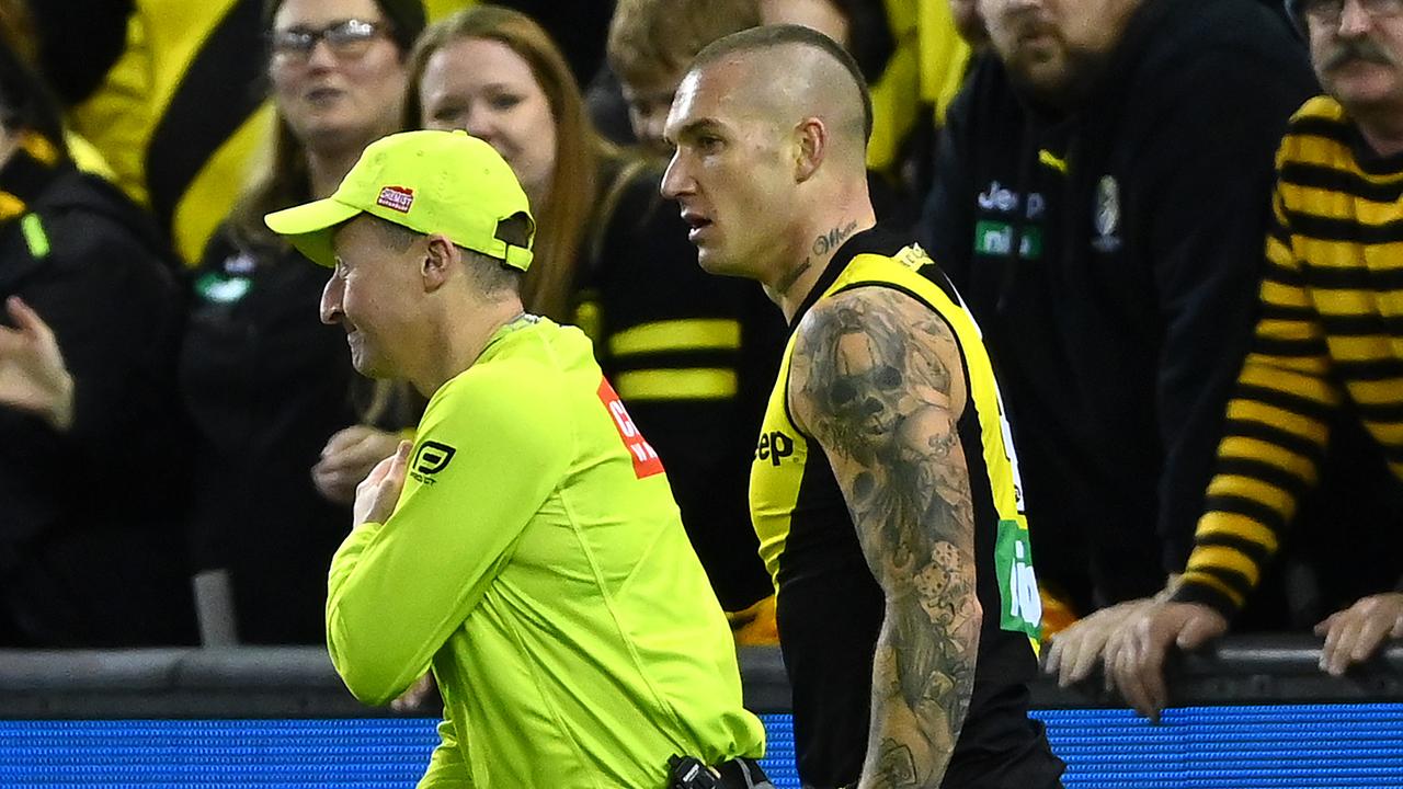 Dustin Martin checks on the umpire Adam Wojcik after colliding with him. (Photo by Quinn Rooney/Getty Images)