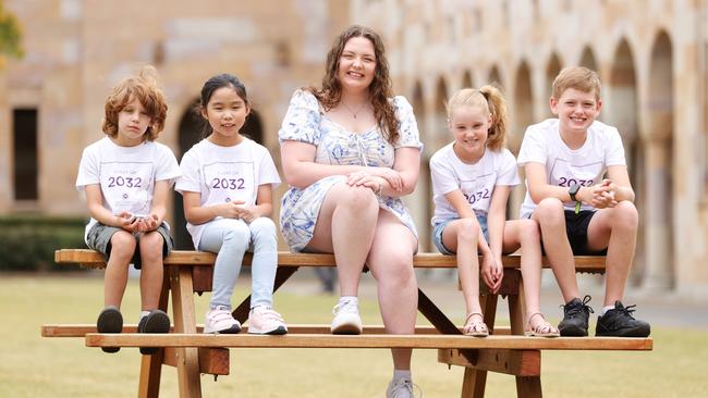 UQ Scholarship recipient Share Liddell who is studying public health with future University students Atticus Yezdani 8, Sophie Song 9, Chelsea Dawson 9, and Caleb Dawson 10, at University of Queensland Campus at St Lucia. Picture Lachie Millard