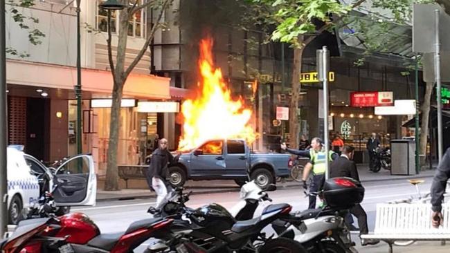 The man confronts police in Bourke St this afternoon. Source: Chris Macheras.