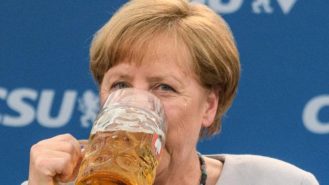 German Chancellor Angela Merkel takes a sip of beer after delivering a speech during a joint campaigning event where she urged European Union nations to stick together in the face of new uncertainty over the United States and other challenges. Picture: Matthias Balk/DPA/AFP