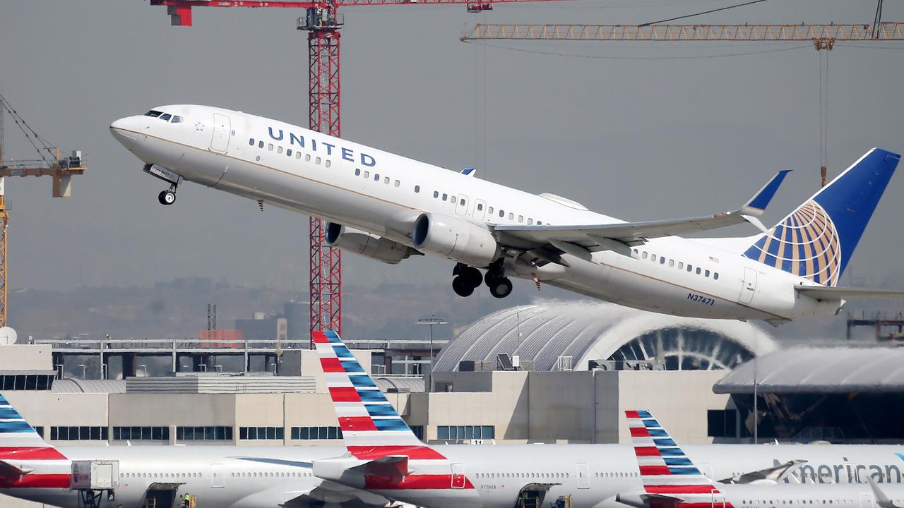 A United Airlines plane takes off above an American Airlines planes on the tarmac at Los Angeles International Airport. Picture: Mario Tama/Getty Images/AFP