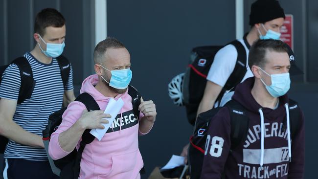 AFL umpire Ray Chamberlain walks to a waiting bus after arriving with the Geelong team at Perth Airport last month