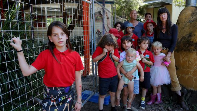 DAILY TELEGRAPH - 22 MARCH, 2022. Main Arm Pulbic School near Mullumbimby has had temporary fencing erected around their main office and school block after recently flooding left the building at risk of being condemned due to the damage. Local parents and students are concerned the small school will remain closed for good. Kirra Jose 10 (L) with a group of parents and their kids. Picture: Toby Zerna