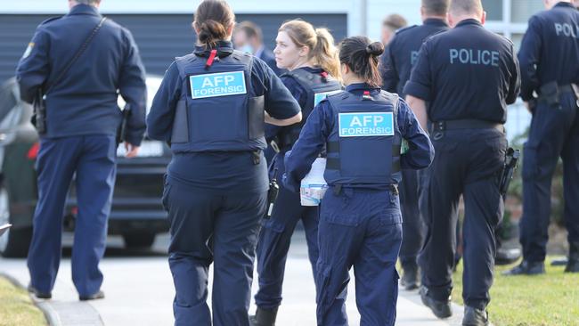 AFP officers search a car outside a Toongabbie property. Picture: John Grainger