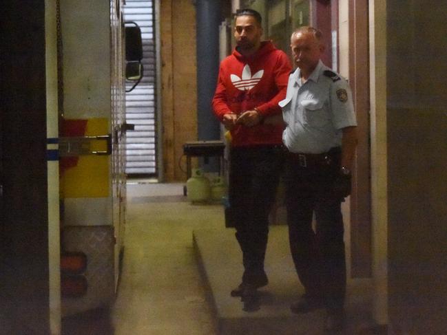 Siar Munshizada led by a Corrective Services Officer to a prison transport vehicle. Picture: Paul Miller / AAP