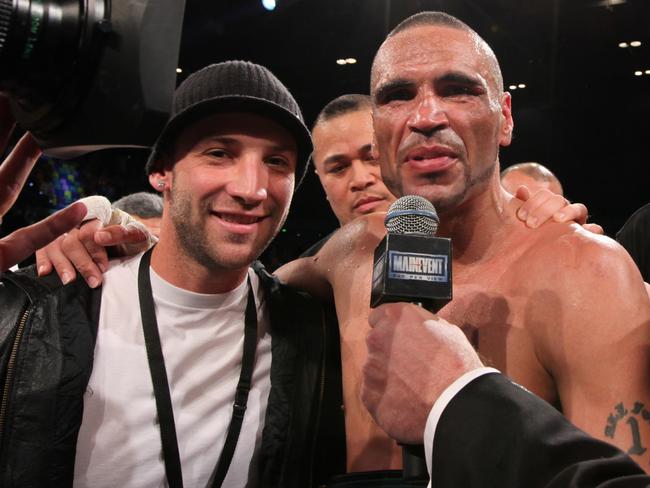 Cricketer Phil Hughes (left) poses with Anthony Mundine after Mundine defeated Daniel Geal to become the new IBO Middleweight World champion at the Brisbane Exhibition Centre on Wednesday, May 27, 2009. (AAP Image/Paul Harris) NO ARCHIVING