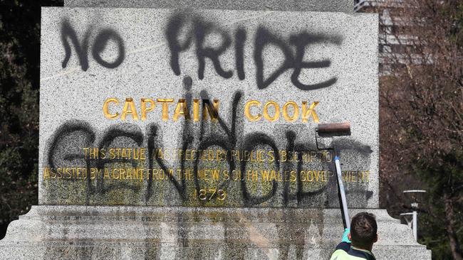 A worker removes graffiti from the Cook statue in Sydney’s Hyde Park.