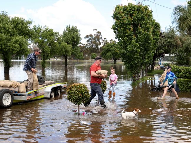 People carry sandbags through flood waters on November 4 in Forbes. Picture: Brendon Thorne