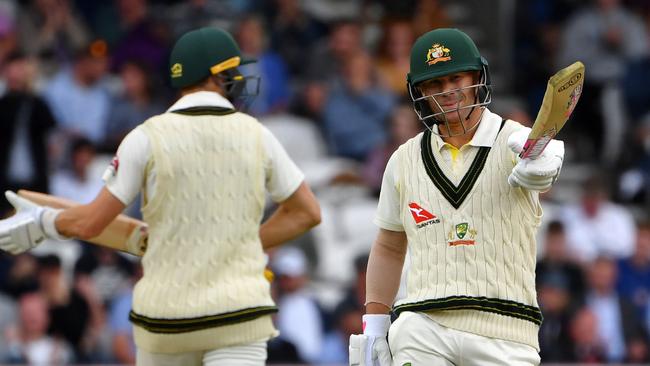 David Warner, right, reacts to scoring a half-century on the first day of the third Ashes cricket Test match between England and Australia at Headingley in Leeds.