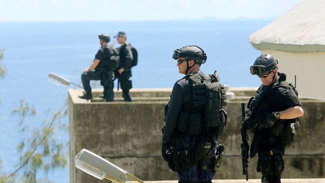 Police from the Regional Assistance Mission to the Solomon Islands stand guard on the roof of Solomon Islands parliament in Honiara.