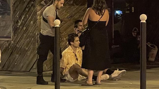 Australian mens hockey player Tom Craig sits on the footpath in Paris after being arrested for allegedly buying cocaine on Tuesday night.