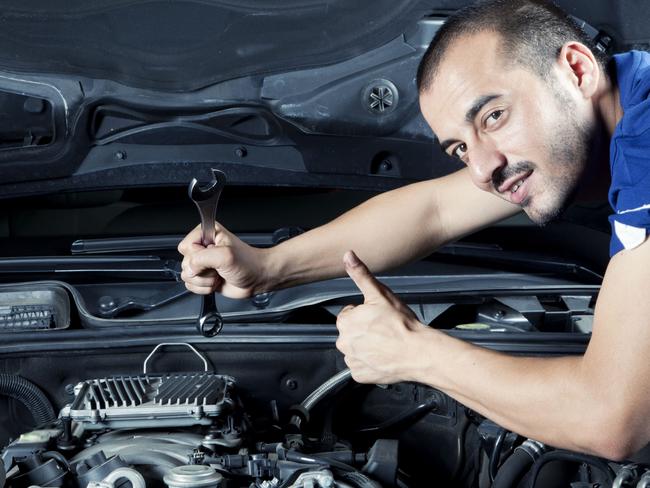 Generic Thinkstock image of serviceman car mechanic with motor car. Giving thumbs up while holding spanner and looking at engine.