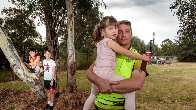 The George family will lose the reserve opposite their house to the North East link. Danniel George with Anna, Samuel and Ryan in the park, with drilling equipment in the background. Picture: Mark Dadswell