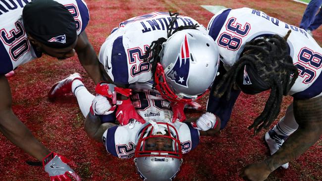 James White is swamped by team-mates after scoring the winning touchdown. Picture: Getty