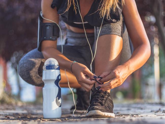 Sporty woman tying shoes to run