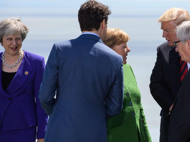 Angela Merkel confers with Donald Trump while Teresa May and Justin Trudeau listen in. Picture: Leon Neal/Getty Images/AFP