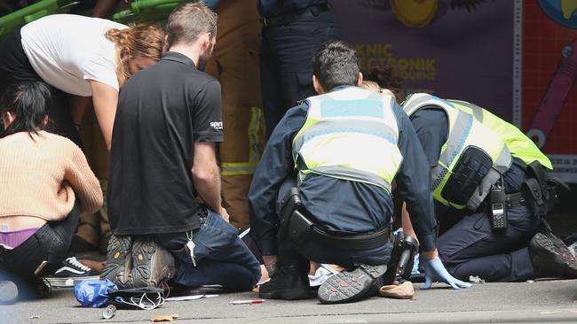 Police and emergency services tend to an injured person in Bourke St. Picture: David Crosling