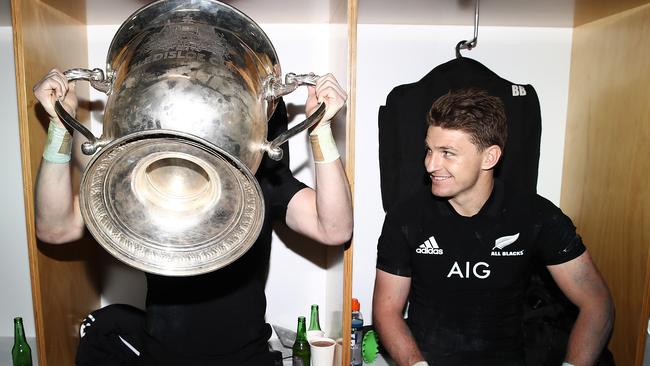 Beauden Barrett grins as brother Jordie sups from the Bledisloe Cup at Eden Park.